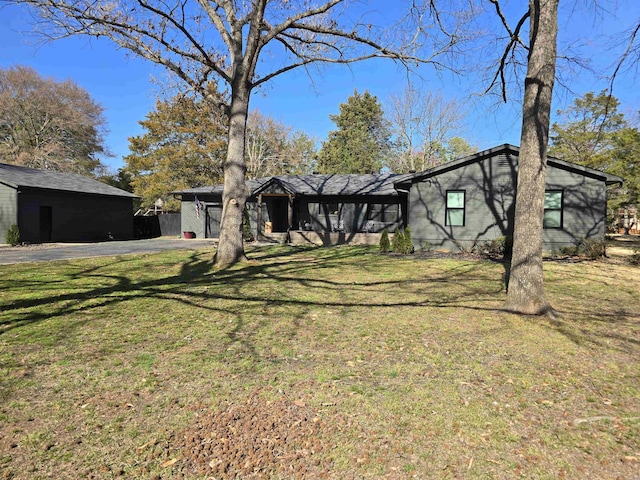 view of front facade featuring a front lawn, a garage, and driveway