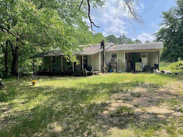 back of property with a porch, cooling unit, and a chimney