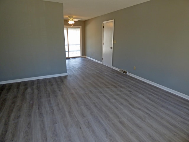 unfurnished room featuring visible vents, baseboards, dark wood-type flooring, and ceiling fan