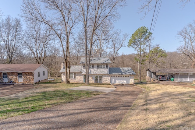 view of front facade with stone siding, a garage, driveway, and a front lawn