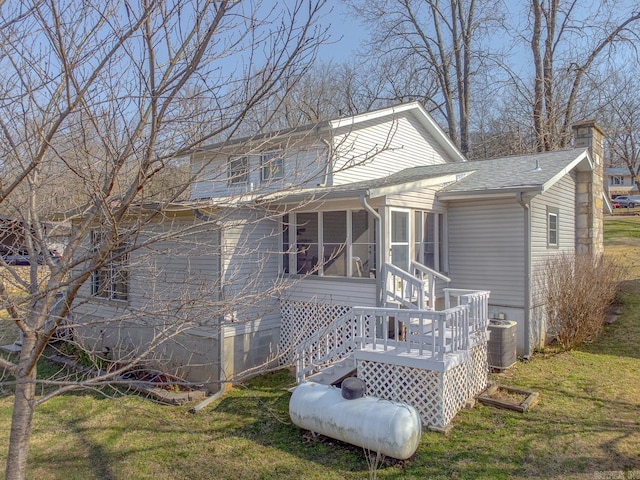 78 Altakima Cir, Cherokee Village, AR 72529 - rear view of house featuring a sunroom, cooling unit, a yard, a shingled roof, and a chimney