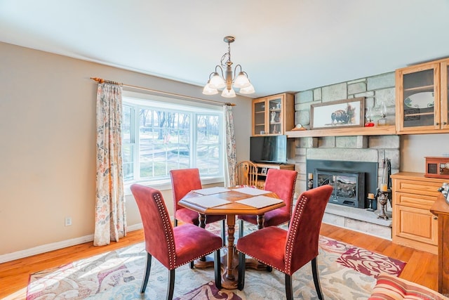 78 Altakima Cir, Cherokee Village, AR 72529 - dining area featuring baseboards, a chandelier, a fireplace, and light wood finished floors