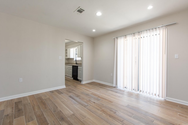 unfurnished living room featuring light wood finished floors, visible vents, recessed lighting, and baseboards