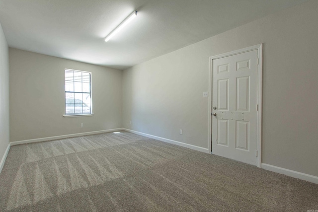 unfurnished room featuring baseboards and carpet