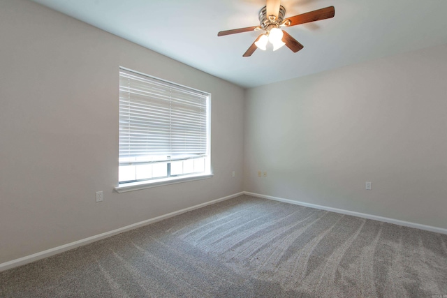 carpeted spare room with baseboards and ceiling fan