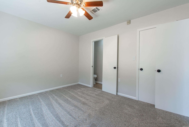 unfurnished bedroom with visible vents, carpet floors, ensuite bathroom, and a ceiling fan