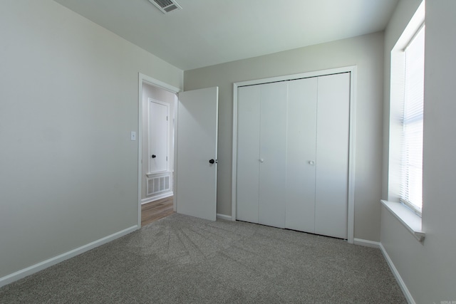 unfurnished bedroom with visible vents, carpet flooring, and baseboards