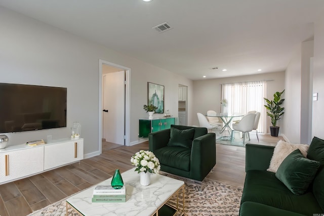 living room featuring visible vents, recessed lighting, baseboards, and wood finished floors