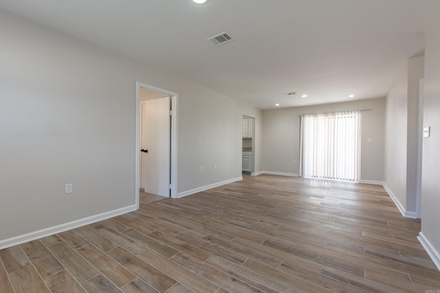 empty room with recessed lighting, visible vents, baseboards, and wood finished floors