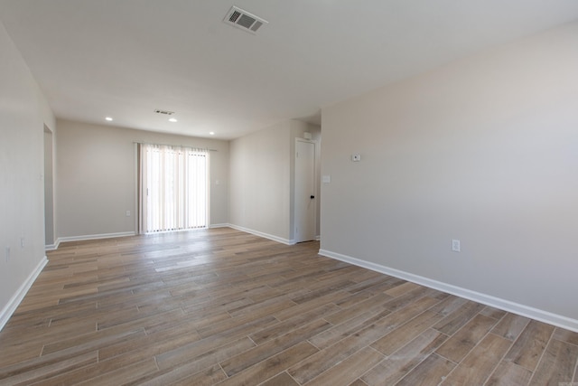 spare room with visible vents, recessed lighting, baseboards, and wood finished floors