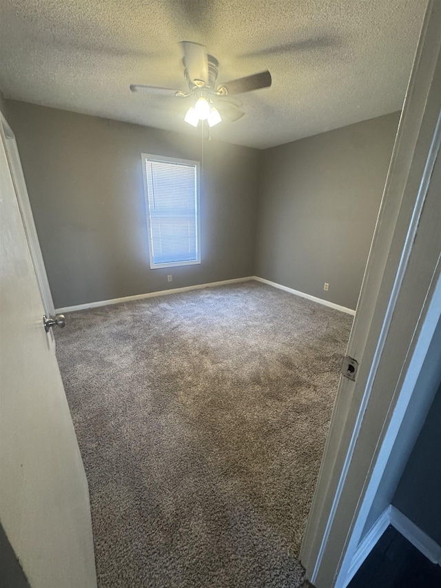 unfurnished bedroom with baseboards, a textured ceiling, ceiling fan, and dark carpet