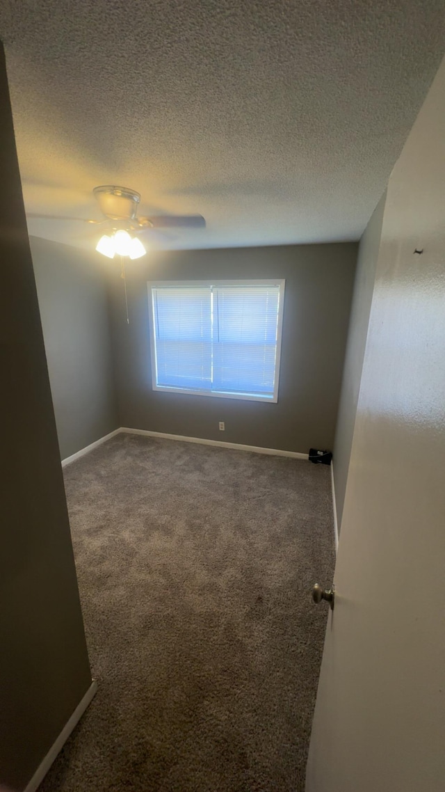 unfurnished room featuring baseboards, a textured ceiling, and carpet flooring