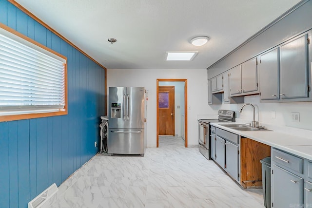 kitchen featuring visible vents, gray cabinetry, a sink, appliances with stainless steel finishes, and marble finish floor