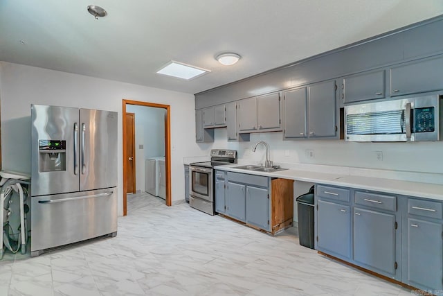 kitchen featuring a sink, marble finish floor, appliances with stainless steel finishes, and light countertops