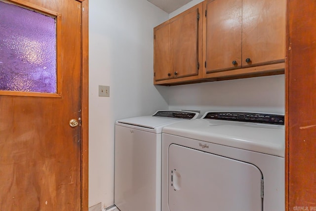 clothes washing area with cabinet space and washer and clothes dryer