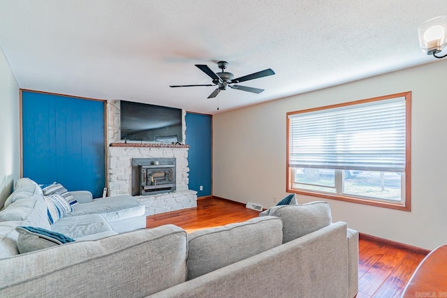 living room with visible vents, baseboards, ceiling fan, wood finished floors, and a textured ceiling