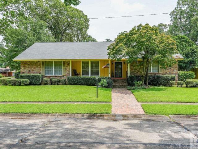 view of front of property featuring brick siding and a front yard