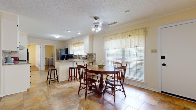 dining space featuring a textured ceiling, baseboards, visible vents, and ceiling fan