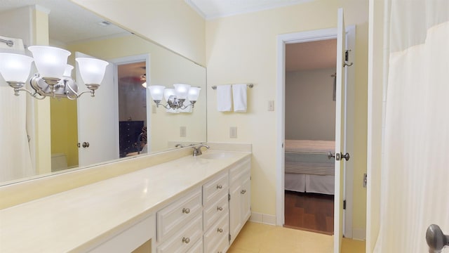 ensuite bathroom featuring baseboards, ornamental molding, ensuite bathroom, tile patterned floors, and vanity