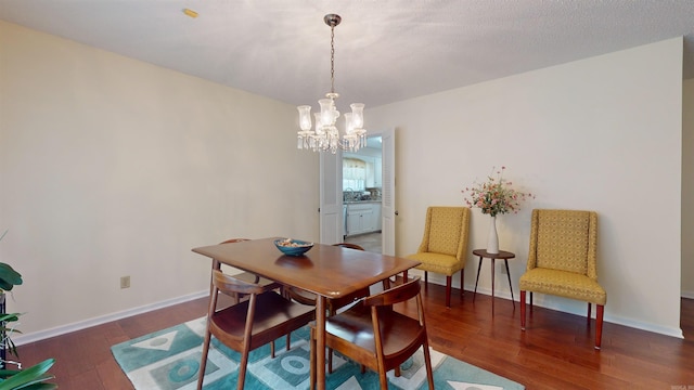 dining space featuring a chandelier, baseboards, and hardwood / wood-style floors