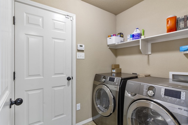 clothes washing area with washer and dryer, laundry area, baseboards, and a textured ceiling