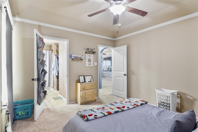 bedroom featuring carpet, baseboards, arched walkways, ceiling fan, and crown molding