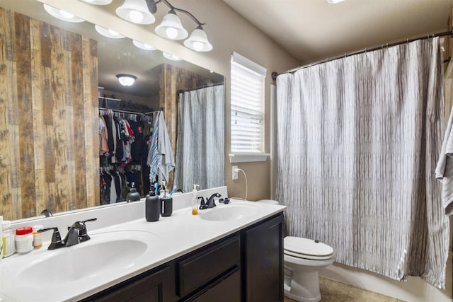 full bath featuring double vanity, tile patterned flooring, toilet, and a sink