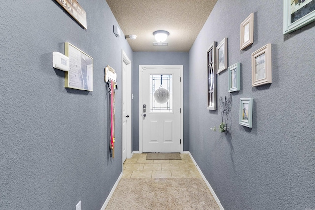 doorway with a textured ceiling, carpet floors, tile patterned flooring, baseboards, and a textured wall