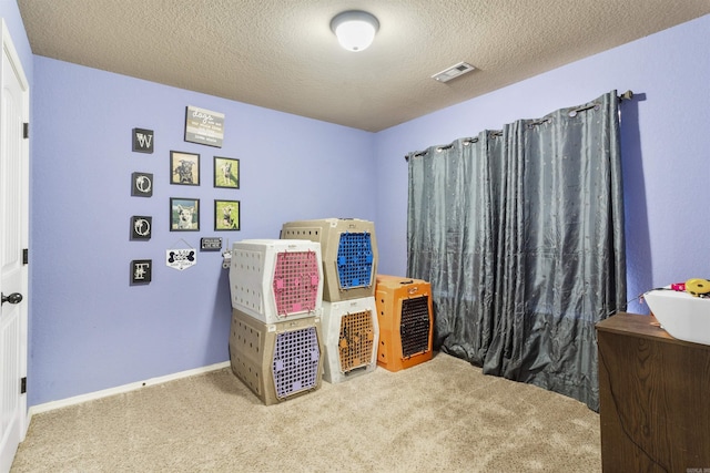 carpeted bedroom featuring visible vents, a textured ceiling, and baseboards