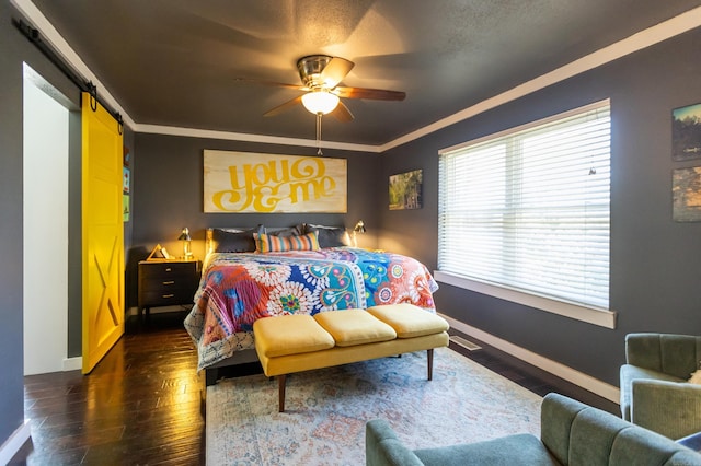 bedroom featuring ornamental molding, a barn door, baseboards, ceiling fan, and dark wood-style flooring