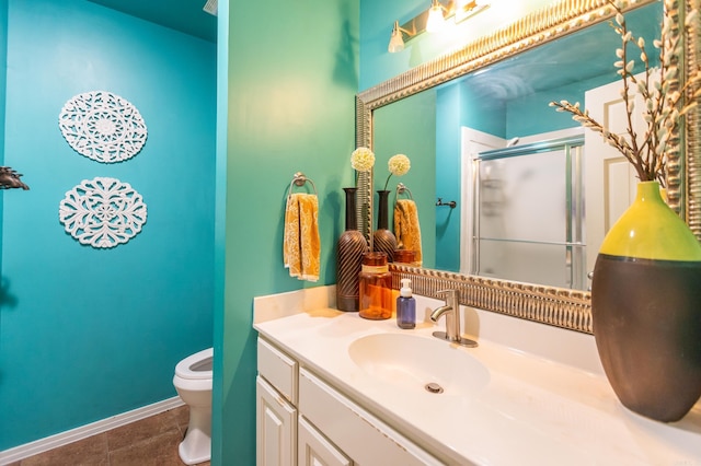 full bathroom with vanity, baseboards, a shower stall, tile patterned floors, and toilet