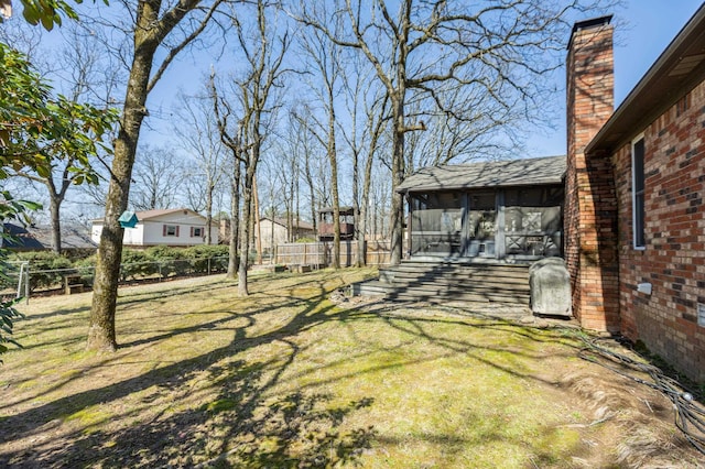 view of yard with fence and a sunroom