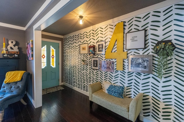 foyer with dark wood-style floors, wallpapered walls, and baseboards