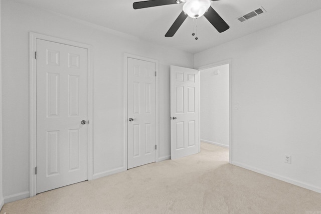 unfurnished bedroom with a ceiling fan, baseboards, visible vents, and carpet floors