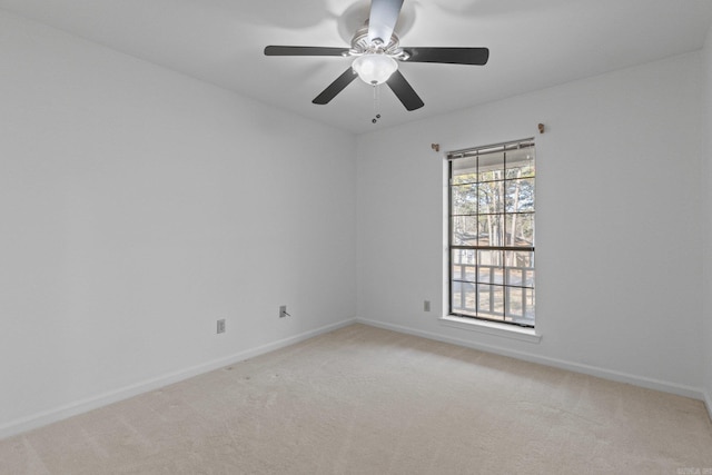 spare room with light colored carpet, baseboards, and ceiling fan