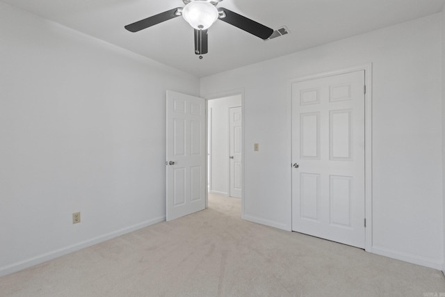 unfurnished bedroom with visible vents, light carpet, baseboards, and a ceiling fan