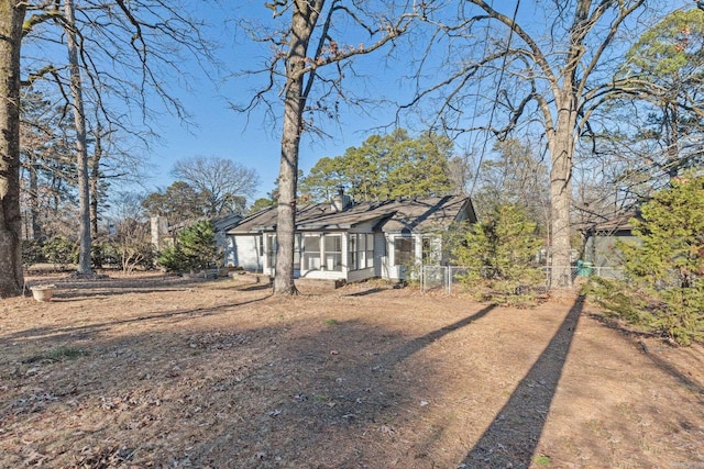 view of front facade with a chimney and fence