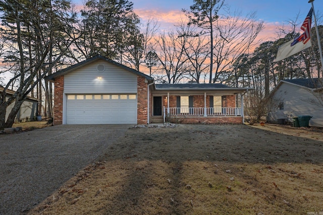 view of front facade with a garage, brick siding, a porch, and concrete driveway