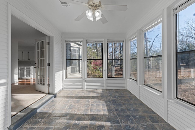 unfurnished sunroom with visible vents and a ceiling fan