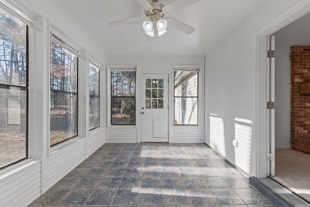 unfurnished sunroom featuring plenty of natural light and a ceiling fan