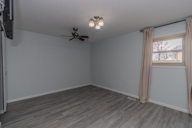 spare room with visible vents, baseboards, ceiling fan, wood finished floors, and a textured ceiling