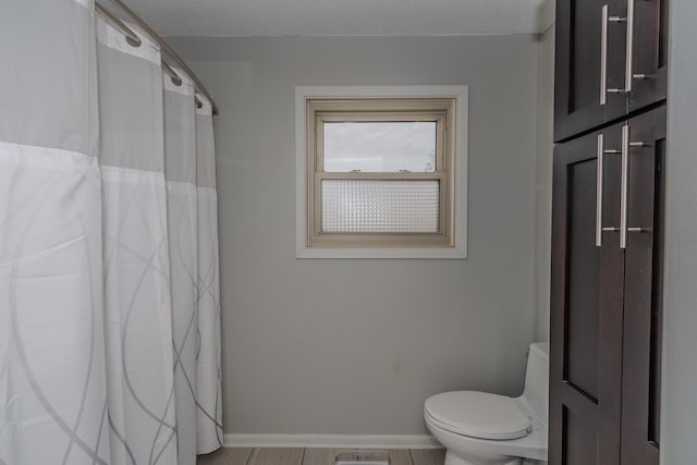 full bathroom with a shower with shower curtain, visible vents, baseboards, and toilet