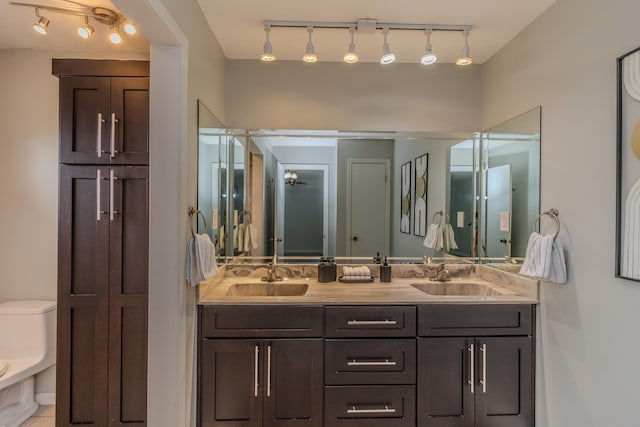 full bathroom featuring a sink, toilet, and double vanity