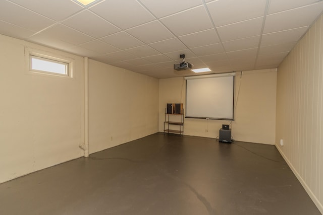 home theater featuring a drop ceiling and concrete flooring