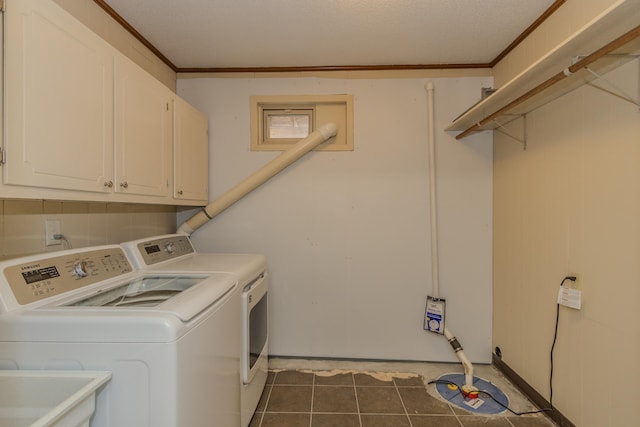 clothes washing area featuring cabinet space, a sink, washer and dryer, crown molding, and dark tile patterned floors