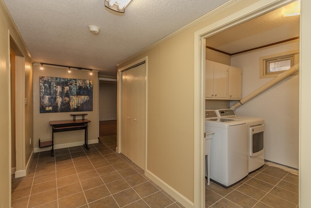 washroom with cabinet space, ornamental molding, tile patterned floors, washer and dryer, and a textured ceiling