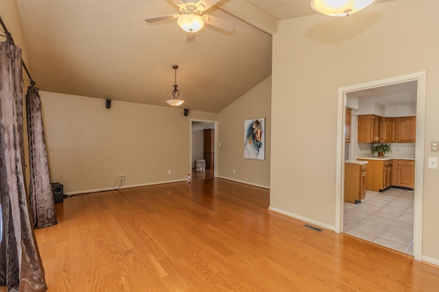 unfurnished living room with visible vents, beamed ceiling, light wood-style floors, baseboards, and ceiling fan