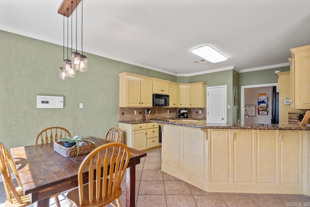 kitchen featuring light tile patterned floors, dark stone countertops, cream cabinets, and black microwave