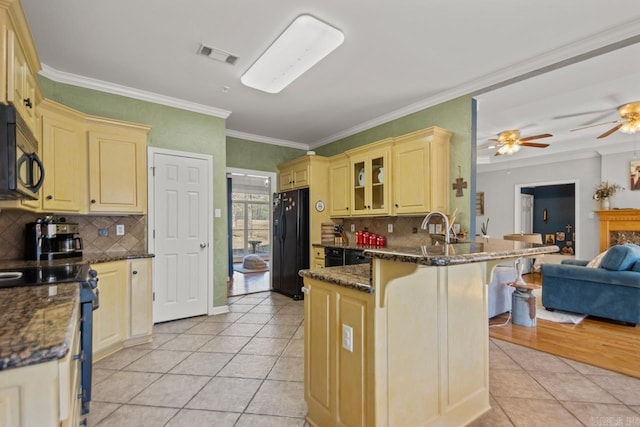 kitchen featuring black appliances, a breakfast bar, a ceiling fan, open floor plan, and a peninsula