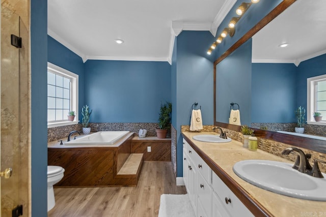 bathroom featuring a bath, wood finished floors, crown molding, and a sink